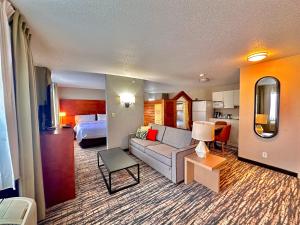 Habitación de hotel con sofá y cama en SureStay Plus by Best Western Fremont I-69, en Fremont