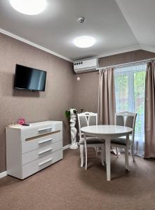 a dining room with a white table and a tv at Hotel Korona in Kropyvnytskyi