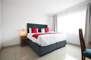 a bedroom with a large bed with red pillows at Safi Luxury Apartment - 3 in East London