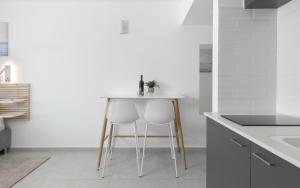 a kitchen with two chairs and a table at סוויטה עם נוף וצמודה לים במתחם SeaSide היוקרתי עם בריכה - By SEAELO EILAT in Eilat