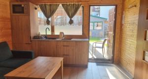 a kitchen with a wooden table and a window at Domki u Wiki in Niechorze
