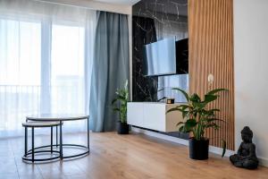 a living room with a table and a tv at Duży apartament in Gdańsk