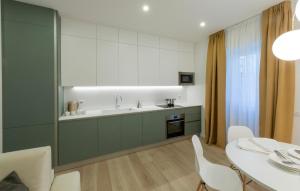une cuisine avec un évier et une table avec des chaises dans l'établissement Residence Casa Coppa Appartamento Aster, à Omegna