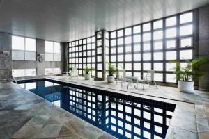 uma grande piscina num grande quarto com janelas em UH 110 Flat Hotel Rua Maestro Cardim - Bela Vista em São Paulo
