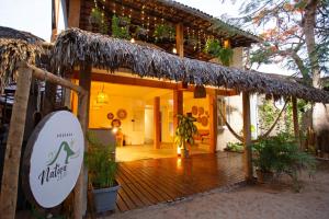 a house with a thatched porch with plants on it at Pousada Nativa Jeri in Jericoacoara