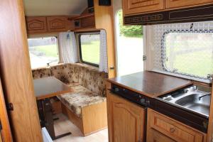 a kitchen in an rv with a sink and a counter at WOODMOOD Caravan Experience in Leuk