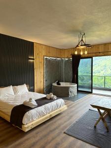 a bedroom with a large bed and a bath tub at Primland Suit in Çamlıhemşin