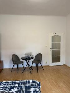 Habitación con 2 sillas, mesa y puerta en No 13 House Raca, en Bratislava