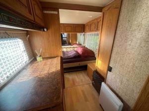 a small room with a bed in an rv at WOODMOOD Caravan Experience in Leuk