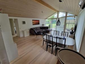 a living room with a table and chairs and a couch at Holiday house by a fantastic beach and free WiFi in Slagelse