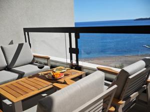 uma varanda com uma mesa e cadeiras e o oceano em Invictus Hotel em Budva