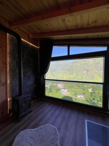 a room with a fireplace and a large window at Primland Suit in Çamlıhemşin