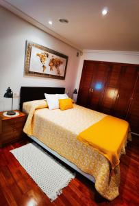 1 dormitorio con 1 cama grande con manta amarilla en Tranquilidad en los Jesuitas, en Toledo