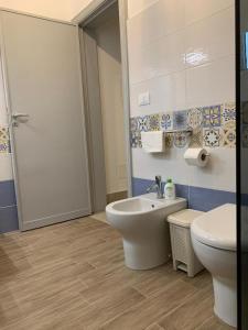 a bathroom with a toilet and a sink at Diana's home in Avola