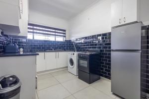 a kitchen with a refrigerator and a washer and dryer at Safi Luxury Apartment - 3 in East London