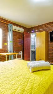 een slaapkamer met een groot bed met een gele deken bij Nuevo Hotel Carmel in Villa Parque Siquiman +112 foto's