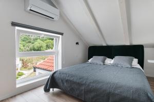 1 dormitorio con cama y ventana grande en Apartments Muller en Mlini