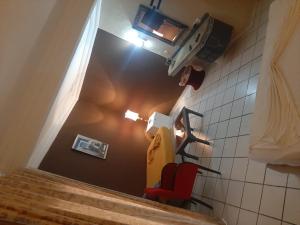 Elle offre une vue sur une chambre dotée d'une chaise rouge et d'une lampe. dans l'établissement Hotel Le Khalife, à Hammamet