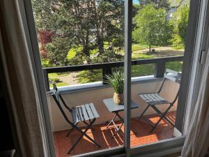 a balcony with two chairs and a table and a potted plant at La douce escapade, Superbe T2, 4 pers - parking, balcon in Villers-sur-Mer +1 photo