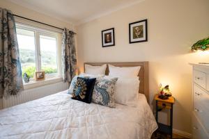 ein Schlafzimmer mit einem Bett mit Kissen und einem Fenster in der Unterkunft River Dale in Kent