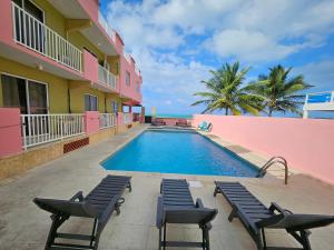 una piscina frente a un edificio con sillas en Selva Boutique Hotel - Luquillo Oceanfront Retreat - Adults Only, en Luquillo