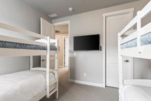 1 Schlafzimmer mit 2 Etagenbetten und einem Flachbild-TV in der Unterkunft Deer Springs 12754 by Moose Management in Keetley