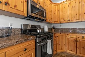 uma cozinha com um fogão e um micro-ondas em Bear Hollow Village 5519 by Moose Management em Park City