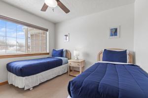 2 letti in una camera da letto con finestra di Bear Hollow Village 5519 by Moose Management a Park City
