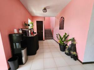 un restaurante con paredes rosas y plantas en una habitación en Selva Boutique Hotel - Luquillo Oceanfront Retreat - Adults Only, en Luquillo