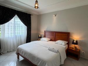 Un dormitorio con una cama grande y una ventana en Akhard Haus en Buea