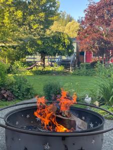 a fire pit with flames in a yard at WHITEWATER COTTAGE in Chilliwack