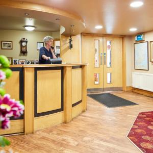 a man standing at a bar in a waiting room at Mahon's Hotel in Irvinestown