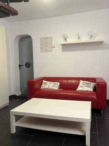 uma sala de estar com um sofá vermelho e uma mesa branca em Fantástica Casa Barco em Pechón