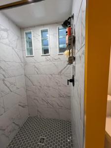 a bathroom with a shower with white tiles at WHITEWATER COTTAGE in Chilliwack