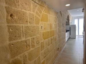 a stone wall in a kitchen with a hallway at Recinto antico Sweet Rooms in Matera