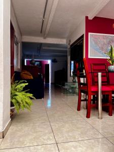 uma sala de estar com uma mesa vermelha e cadeiras em Posada Mi Rey em Guadalajara