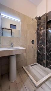 La salle de bains est pourvue d'un lavabo et d'une douche avec un miroir. dans l'établissement Hotel RivierA, à Durrës