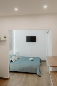 ein Schlafzimmer mit einem Bett in einem weißen Raum in der Unterkunft Barù home in centro in Palermo