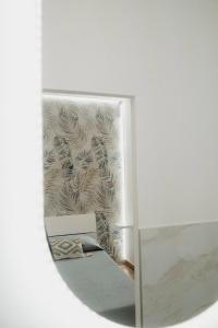 einen Spiegel in einem Zimmer mit einer Wand in der Unterkunft Barù home in centro in Palermo