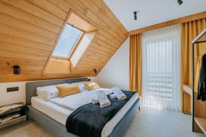 ein Schlafzimmer mit einem Bett mit Holzdecke in der Unterkunft Honstryk Relax & Fun Apartamenty z balią i przestrzenią dla rodzin in Krempachy