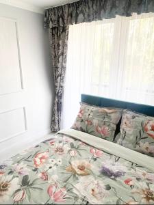 um quarto com uma cama com flores em Jaukus butas Jonavoje em Jonava