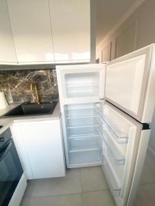 a white refrigerator with its door open in a kitchen at Jaukus butas Jonavoje in Jonava