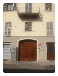 un edificio con una porta di legno e un balcone di Casapiccy a Torino