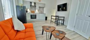 - un salon avec un canapé orange et 2 tables dans l'établissement Stylish 1- Bed Apartment Wakefield with Parking, à Wakefield