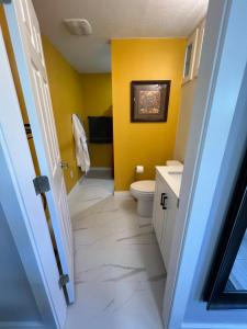 a bathroom with a toilet and a yellow wall at WHITEWATER COTTAGE in Chilliwack