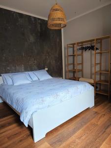 恩波利的住宿－Loft 21，卧室设有一张白色大床和一个大墙