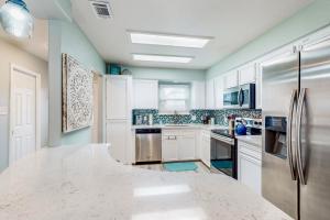 a kitchen with white cabinets and a large white counter top at Blue Crab Bungalow in Padre Island