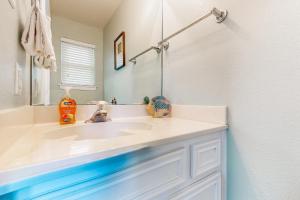 a bathroom with a white sink and a mirror at Blue Crab Bungalow in Padre Island +19 photos