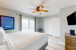 a bedroom with a bed and a ceiling fan at Blue Crab Bungalow in Padre Island
