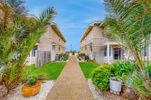 a pathway between two houses with palm trees at Blue Crab Bungalow in Padre Island